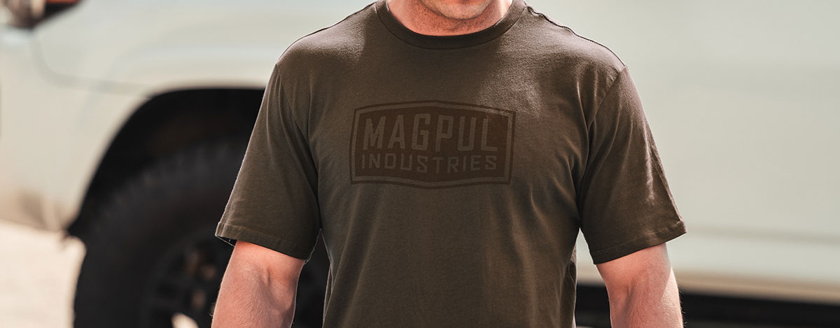 Brown Magpul Industries Fine Cotton T-Shirt worn by an unidentifiable man with a white truck in the background